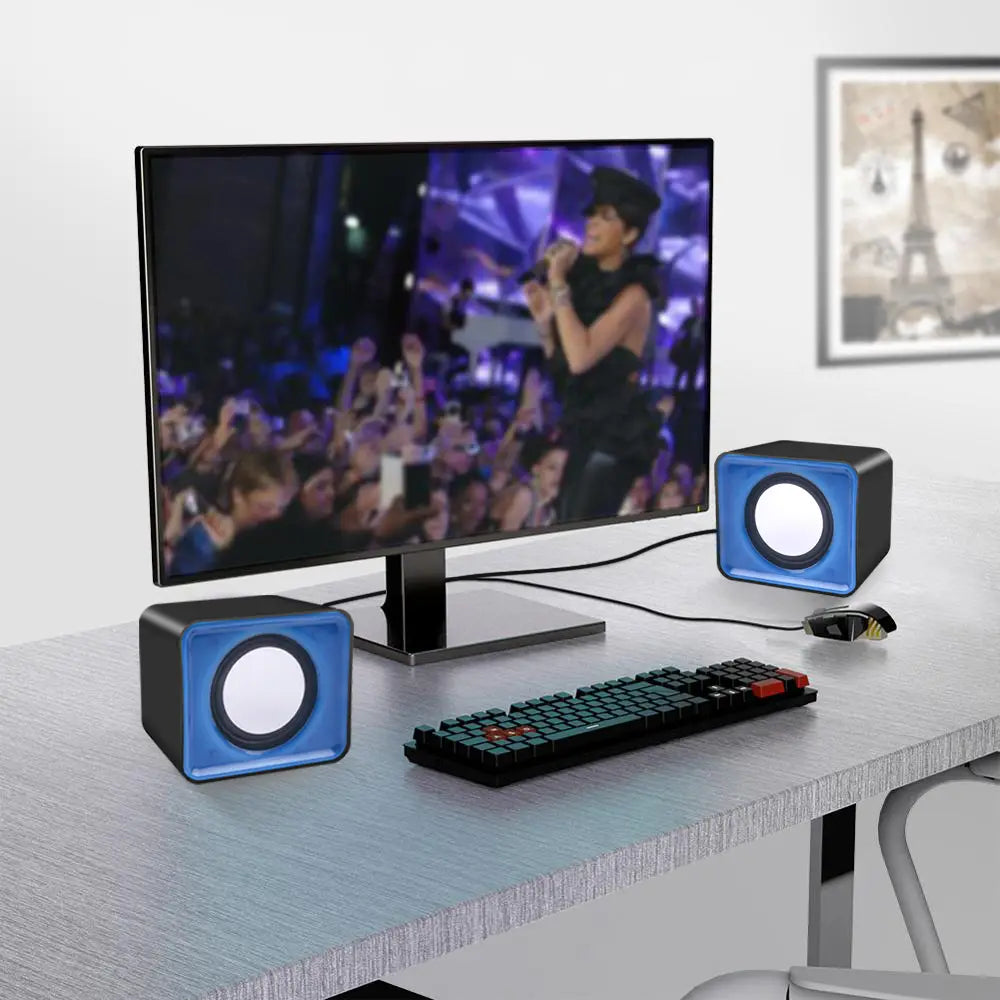 Blau-schwarze, würfelförmige USB-Mini-Computermuslautsprecher mit runden weißen Lautsprechergittern, ausgelegt für Stereo-Desktop-Audiosysteme.