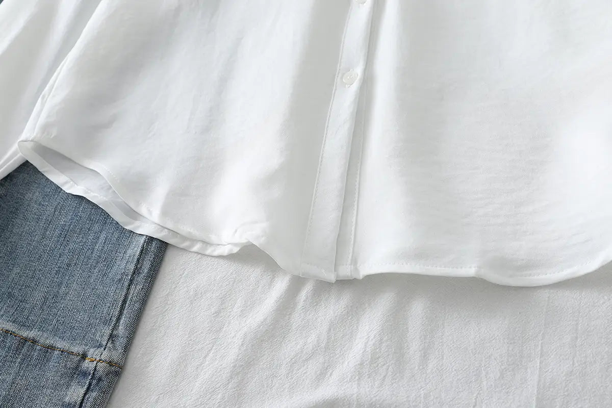 Damen-Casualbluse aus Baumwollmischgewebe mit langen Ärmeln in Weiß mit einer weichen, leicht zerknitterten Textur und einem ordentlich vernähten Kragen.