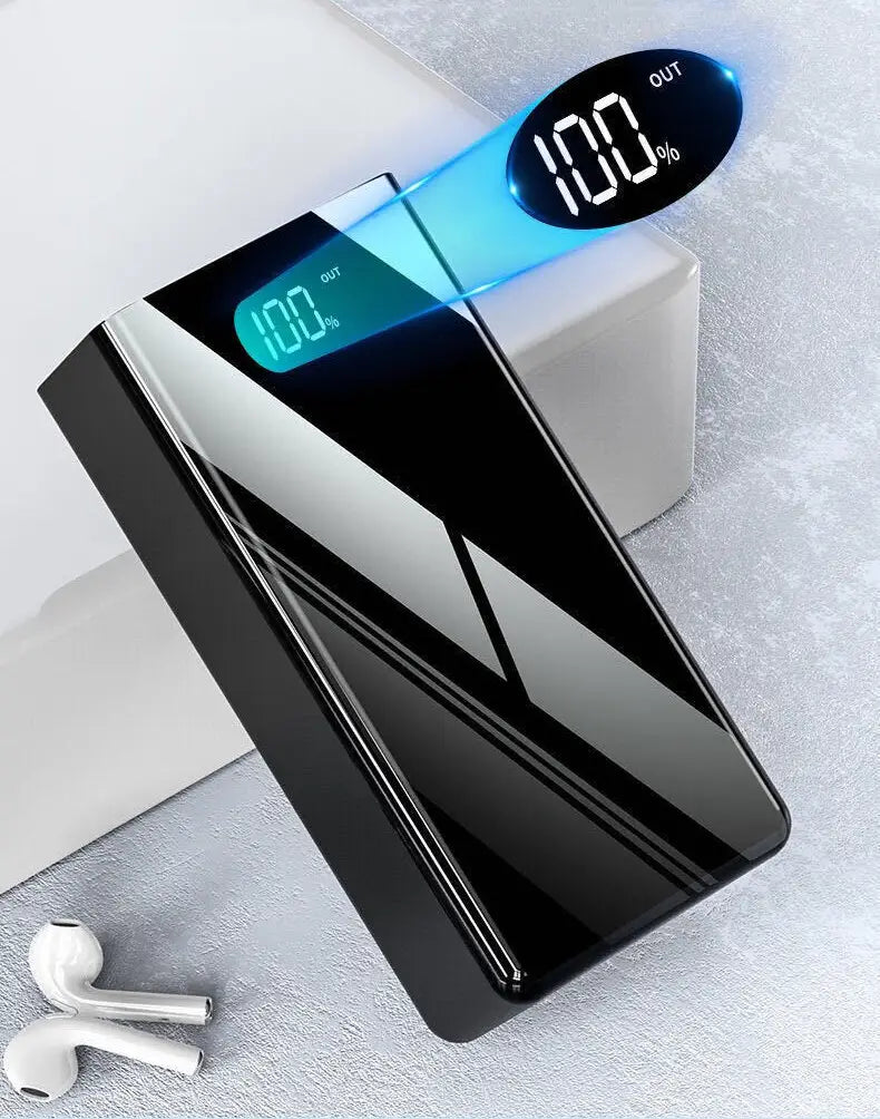Banco de energía rectangular negro con acabado brillante y franjas diagonales plateadas, con una pantalla LED digital que muestra el 100% de carga para dispositivos de carga compatibles con capacidad de 60000 mAh.