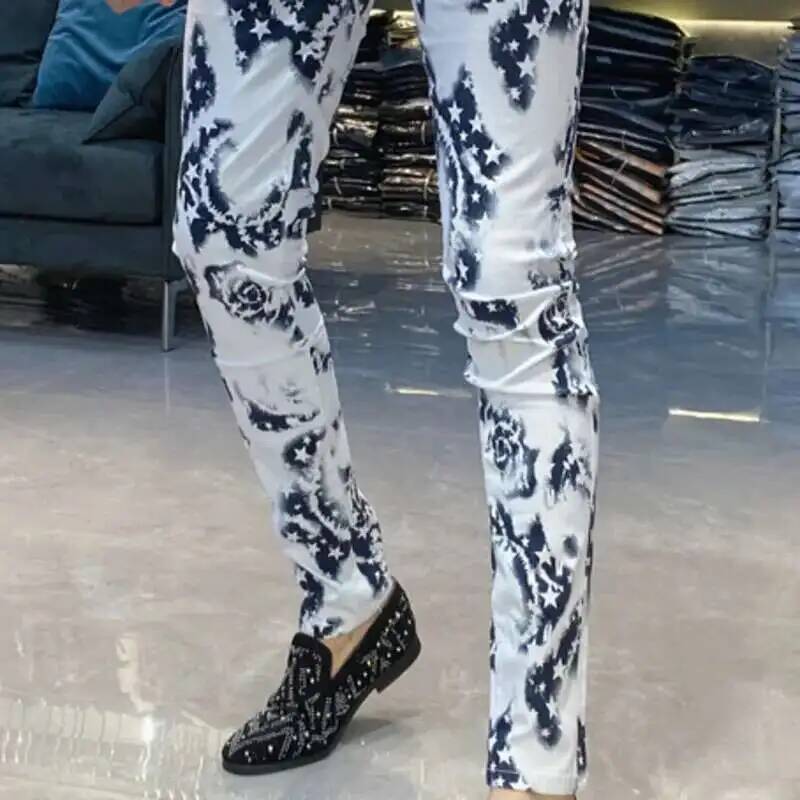 Men black floral slim fit jeans in white denim featuring black floral and star patterns with a slim fit design.