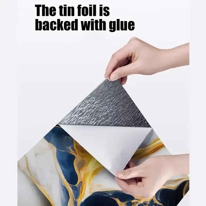 Respaldo de lámina de estaño texturizada plateada con respaldo adhesivo mostrado en el reverso de las pegatinas para azulejos, con mural decorativo de mármol azul y dorado en la pared, para paneles de mármol autoestáticos a prueba de agua con autoadhesivo.