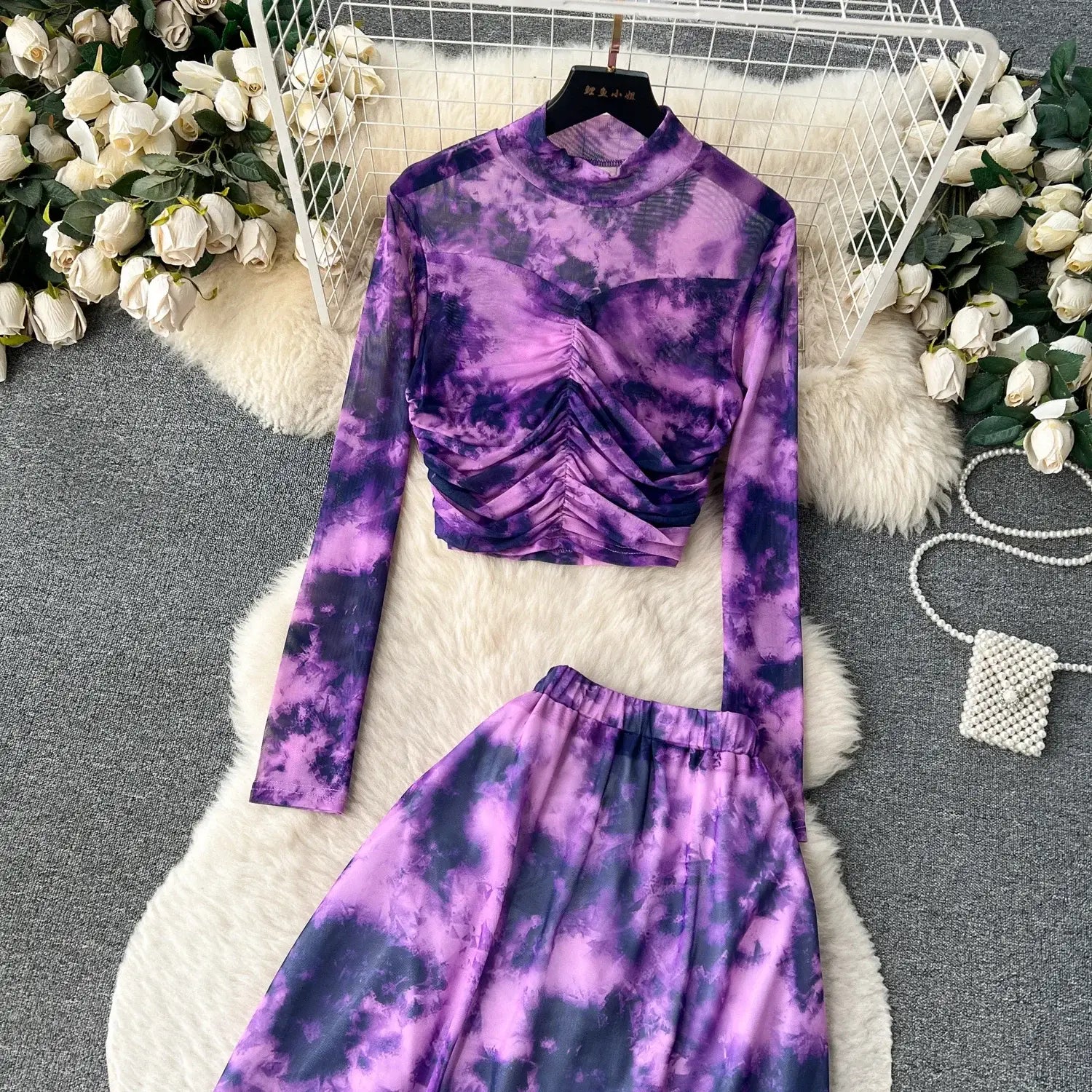 purple and navy tie-dye long-sleeved crop top with ruched bodice paired with matching high-waisted mesh skirt featuring elastic closure in marble print two piece skirt set.