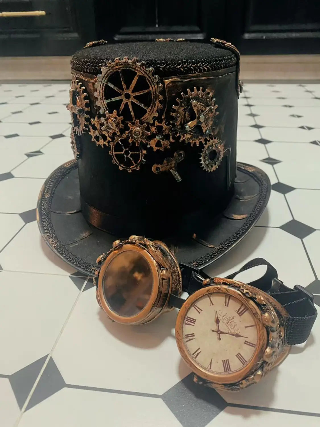 Black steampunk top hat adorned with brass gears and intricate metalwork paired with copper-toned goggles featuring a clock face in the steampunk top hat with goggles and gears product.