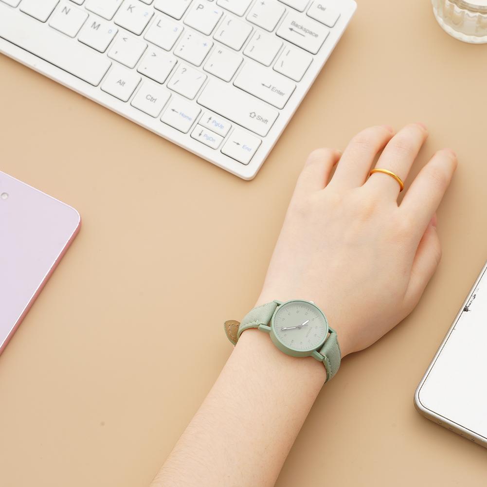 A delicate mint green women quartz watch with a minimalist round face and subtle gold tone accents featuring a pu leather waterproof strap.