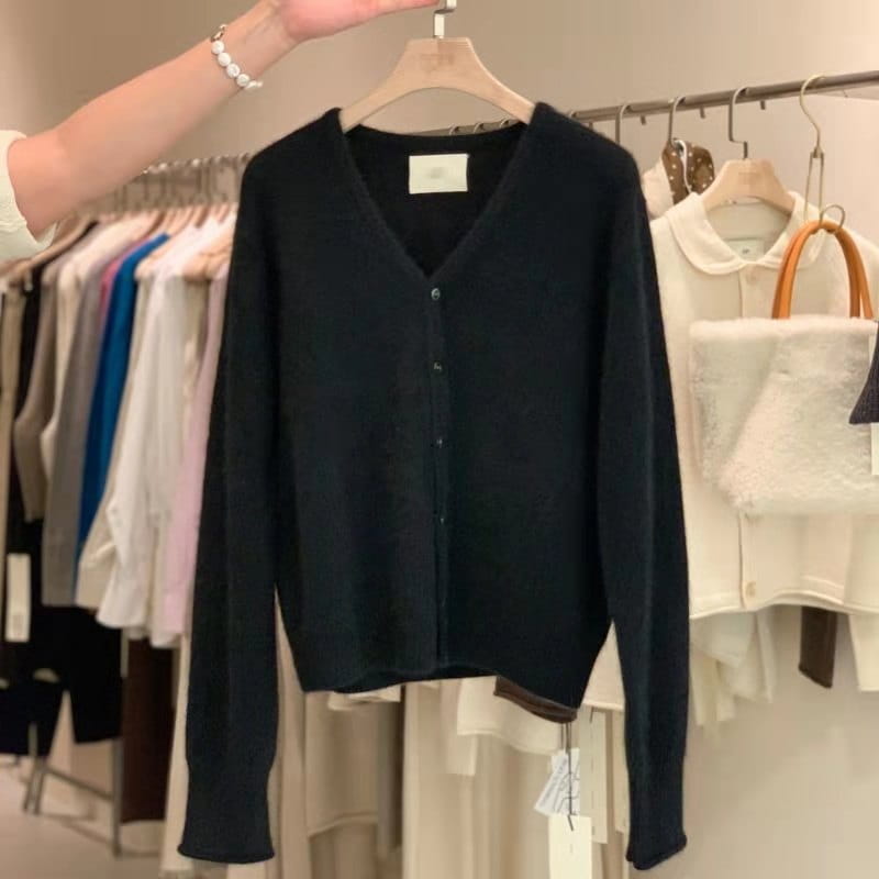 Un pull cardigan en laine mérinos noir à encolure en V, à manches longues et à fermeture boutonnée.