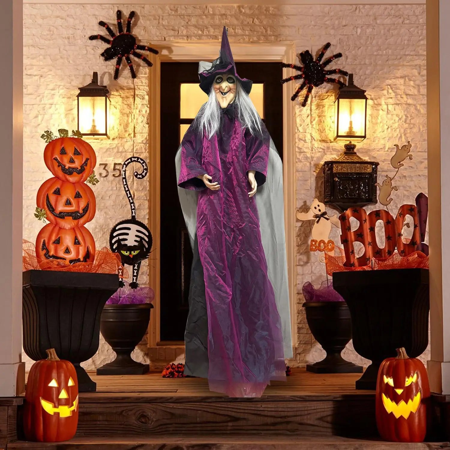 Accessoire de sorcière d’Halloween à activation sonore grand format, violet et gris, avec un chapeau pointu et de longs cheveux blancs, placé devant une porte.