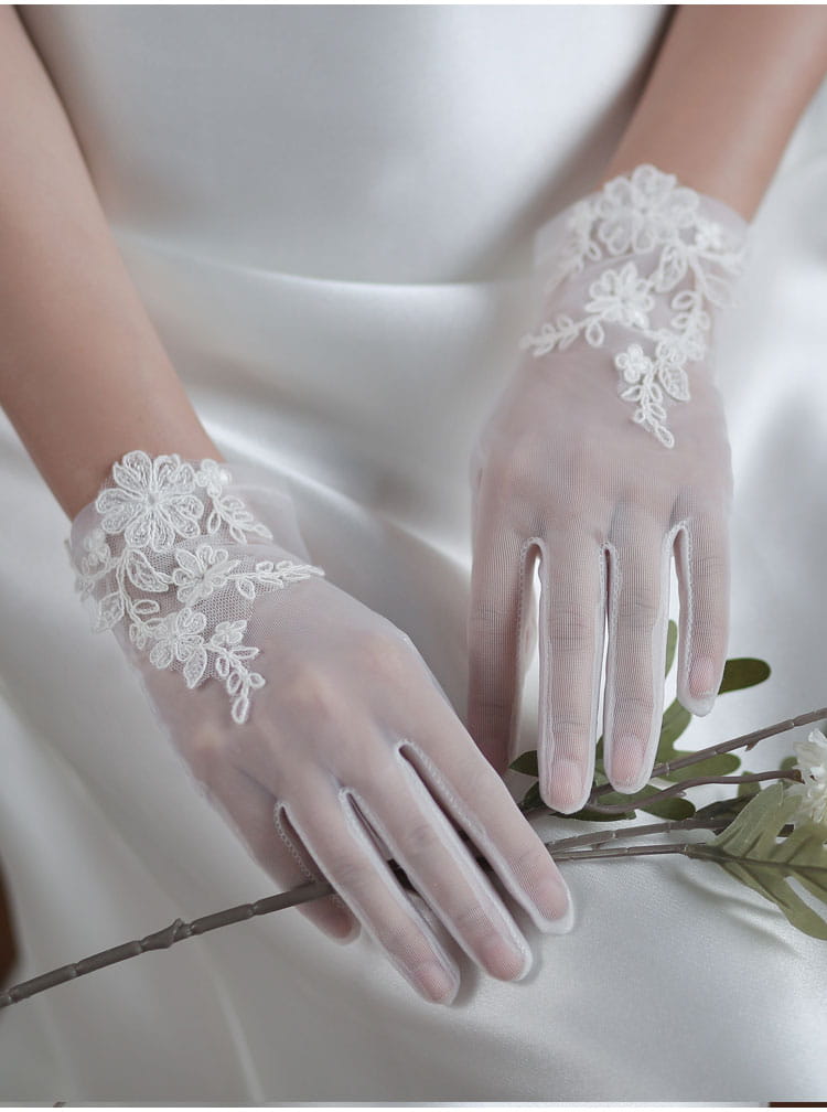 white lace bridal gloves short wedding tulle applique featuring delicate floral embroidery along the wrist in white lace material.