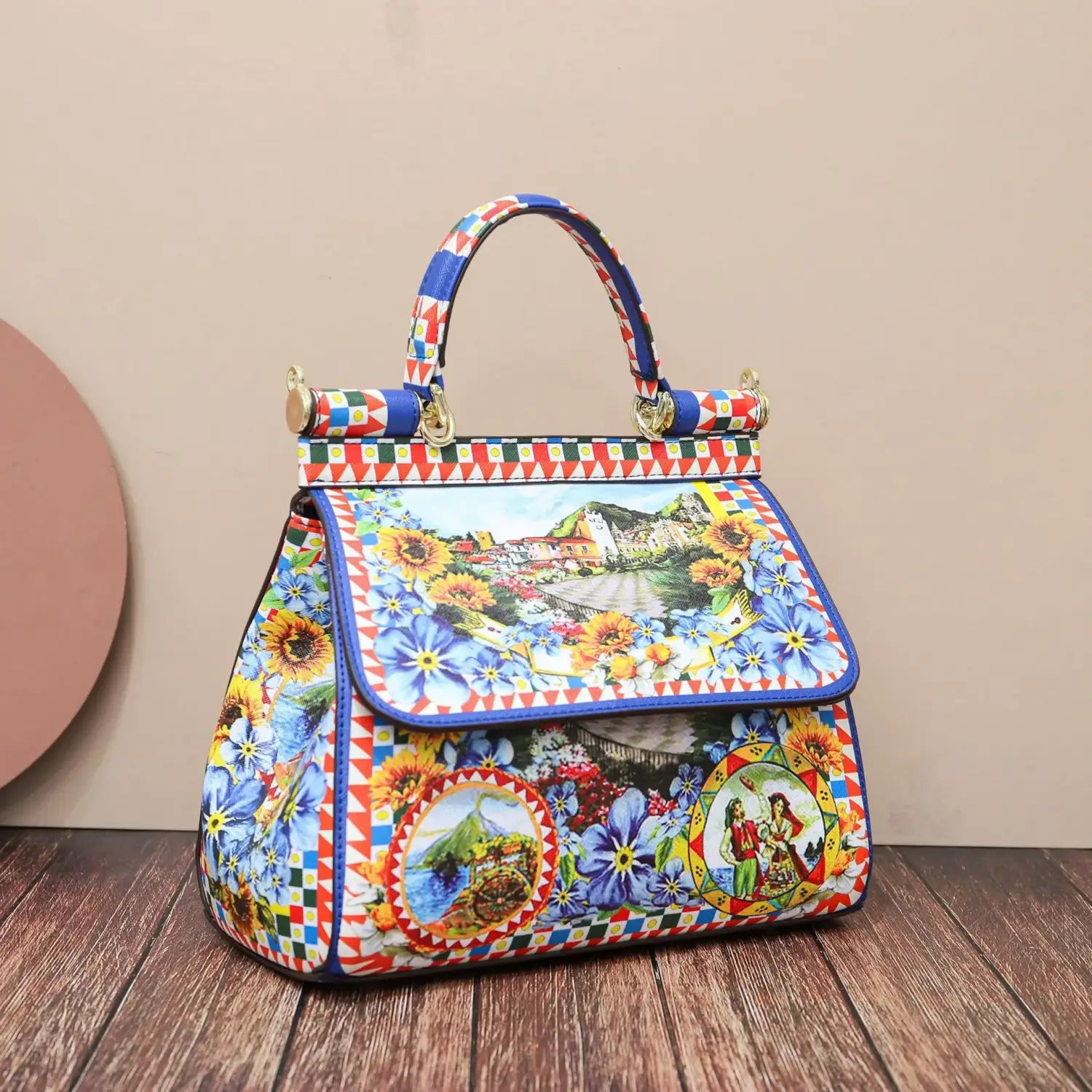 Sac bandoulière en cuir vintage, art raffiné, présentant un cuir imprimé floral et paysages, avec des motifs bleu, rouge, jaune et vert particulièrement marqués.