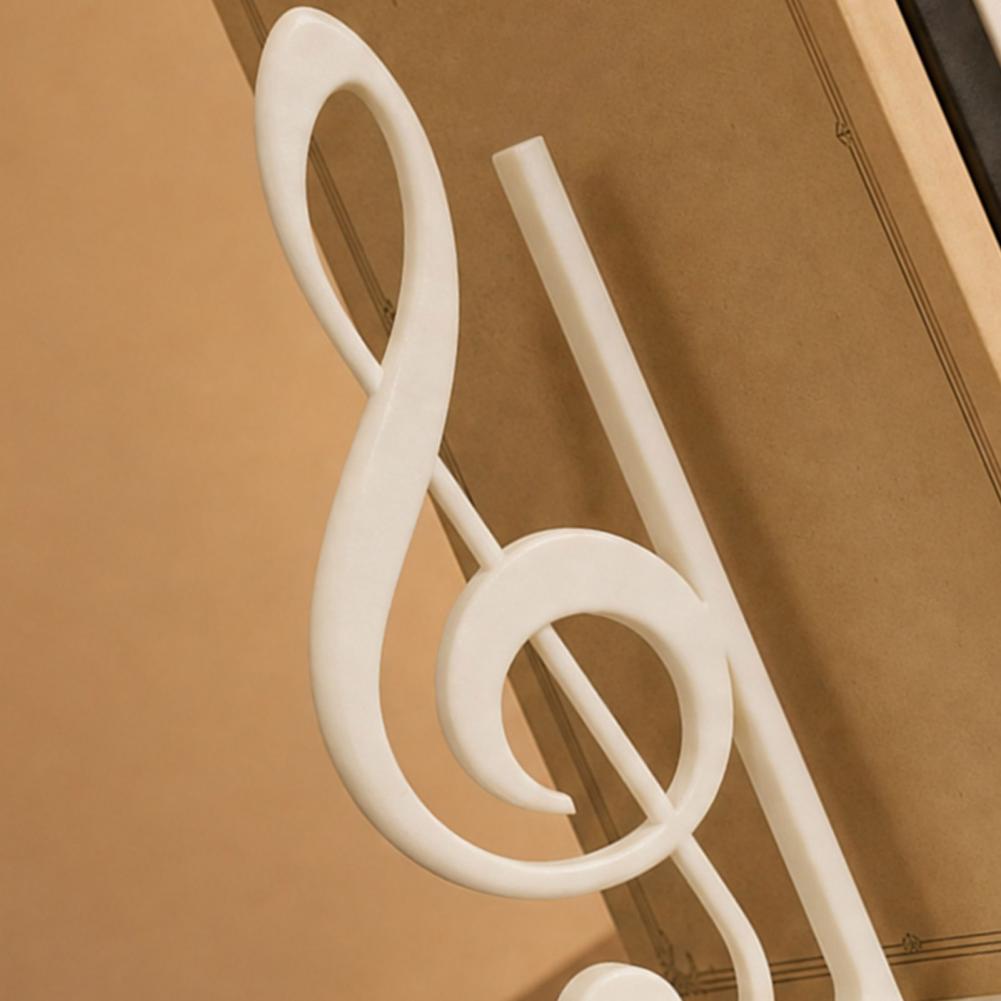 Weiße Kunststoff-Dekoration in Form eines Violinschlüssels, vorgestellt als Teil von 3D-gedruckten Musikdekorationen für Violinschlüssel-Buchstützen.