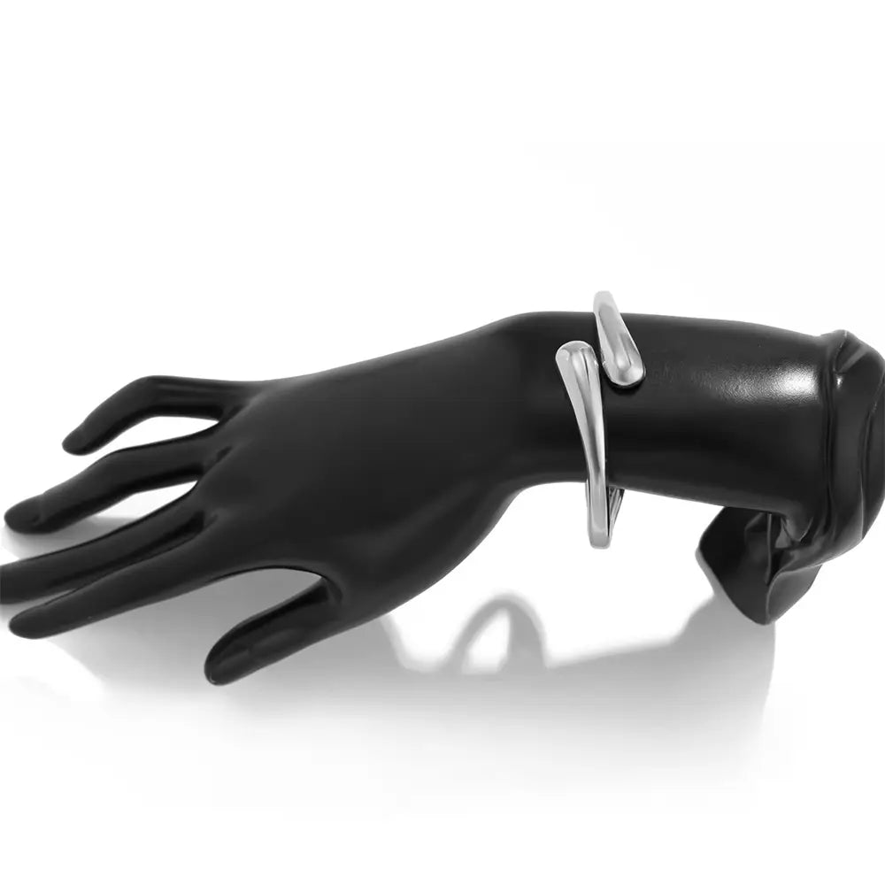 silver color chunky wide metal bangle with a minimalist curved design displayed on a black mannequin hand