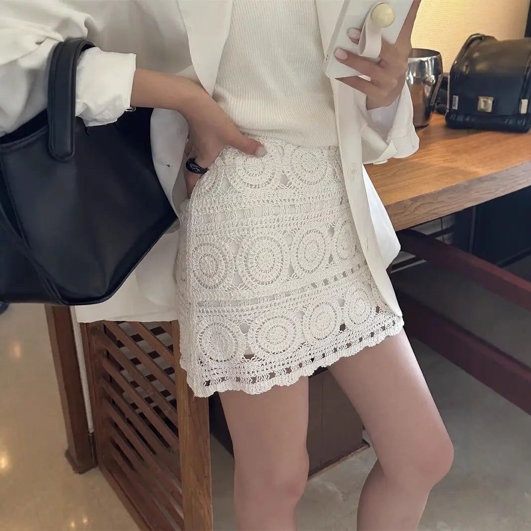 white crochet mini skirt featuring circular lace patterns and scalloped hem in off-white crochet lace suitable for summer wear