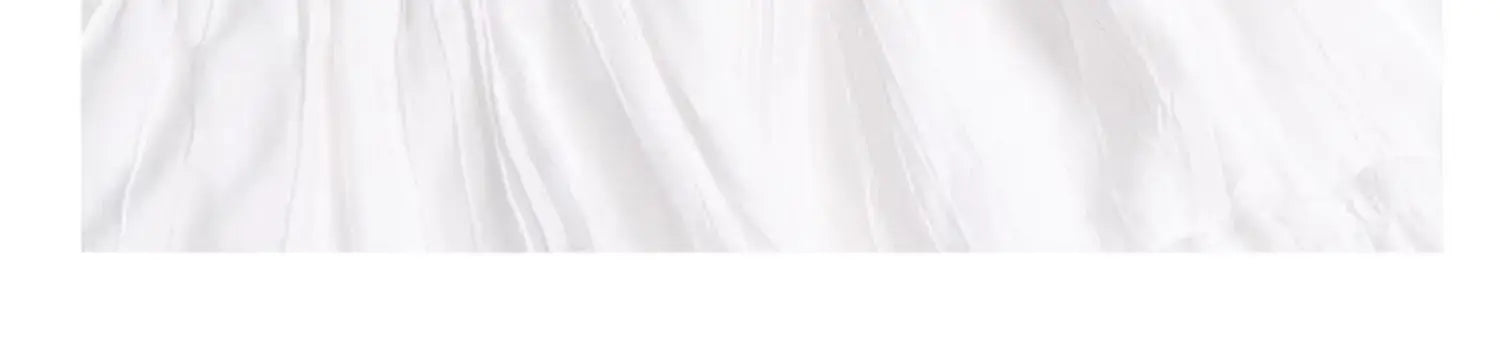 Jupe longue maxi plissée à volants superposés blanche, réalisée dans un tissu blanc, avec des plis souples et une texture délicate
