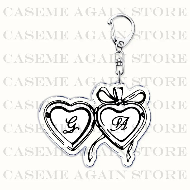 silver heart-shaped acrylic keychain inspired by gracie abrams featuring two interlocking hearts engraved with monograms and tied with a ribbon design ideal as an anime fan gift