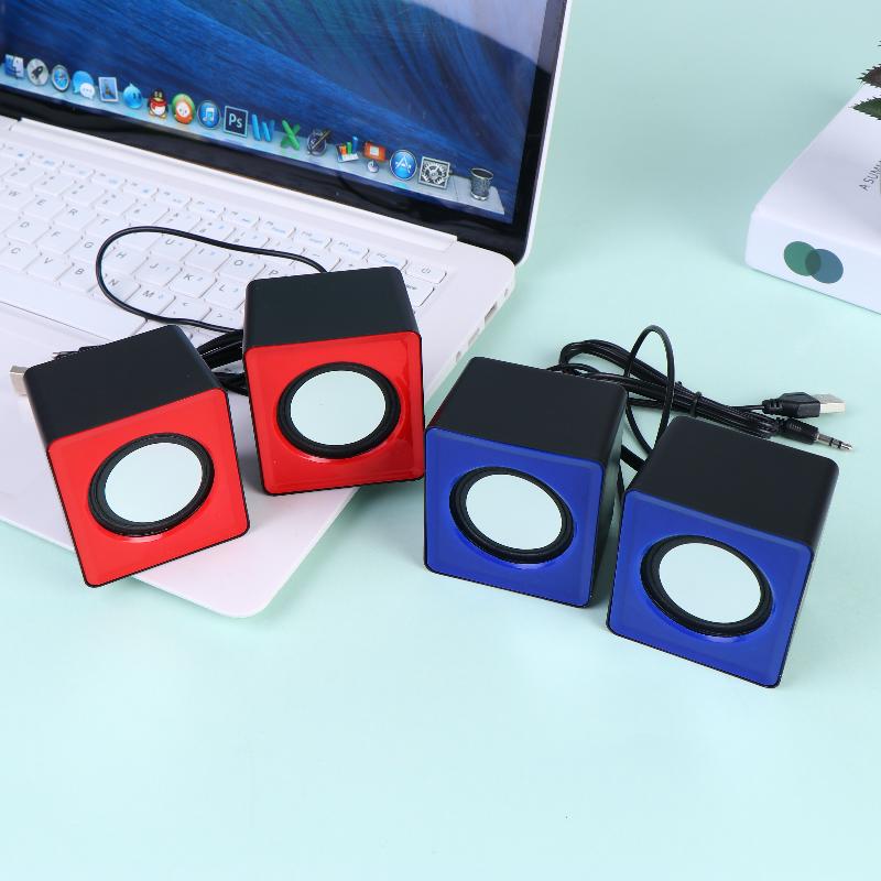 Ensemble de quatre mini haut-parleurs de bureau USB en forme de cube, rouges et bleus, avec des dessus noirs, dotés de haut-parleurs circulaires blancs pour l’audio stéréo sur ordinateur.