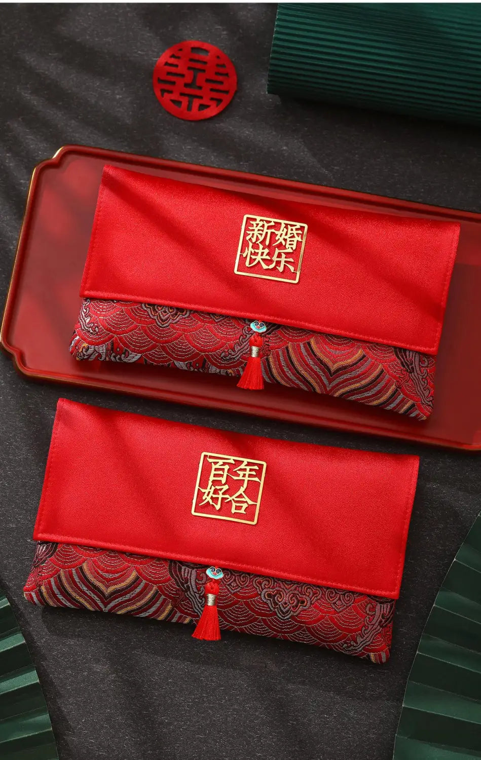 赤色のサテン素材に金色の刺繍入りの中国語文字と房飾りを備えた結婚式用封筒ギフト袋。