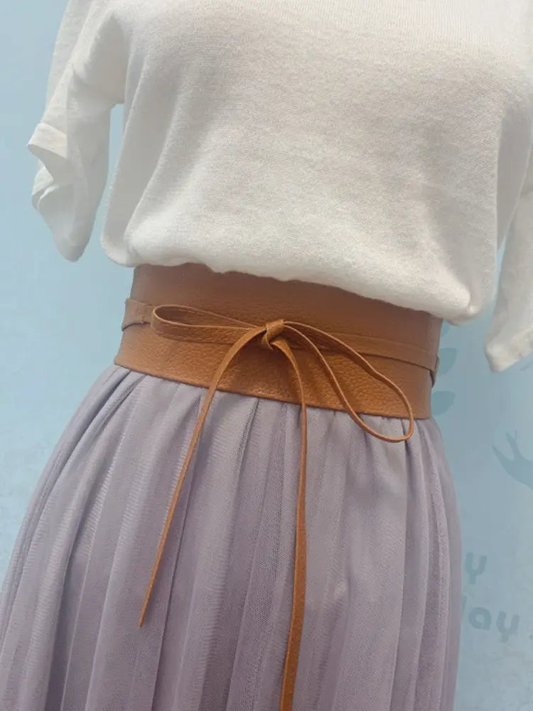 Ceinture large en cuir à nœud papillon noué pour femmes en cuir camel, avec un nœud noué à l’avant.
