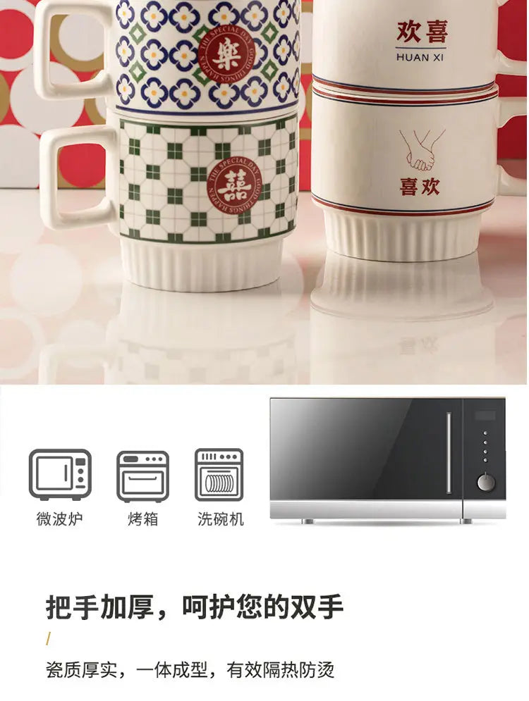Des tasses en céramique empilées présentent des motifs géométriques vert et bleu sur fond blanc, ainsi que des caractères chinois rouges, issues du coffret cadeau de deux tasses de couple en céramique pour mariage chinois.