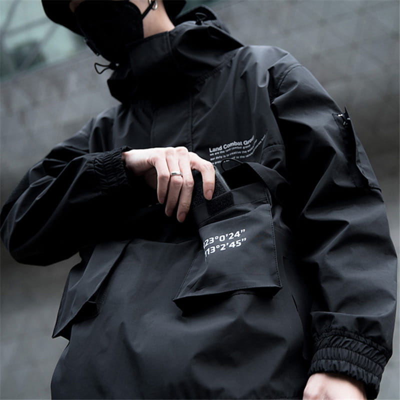 Veste imperméable à capuche tactique techwear noire, avec capuche comportant du texte blanc sur la poitrine et sur la poche.