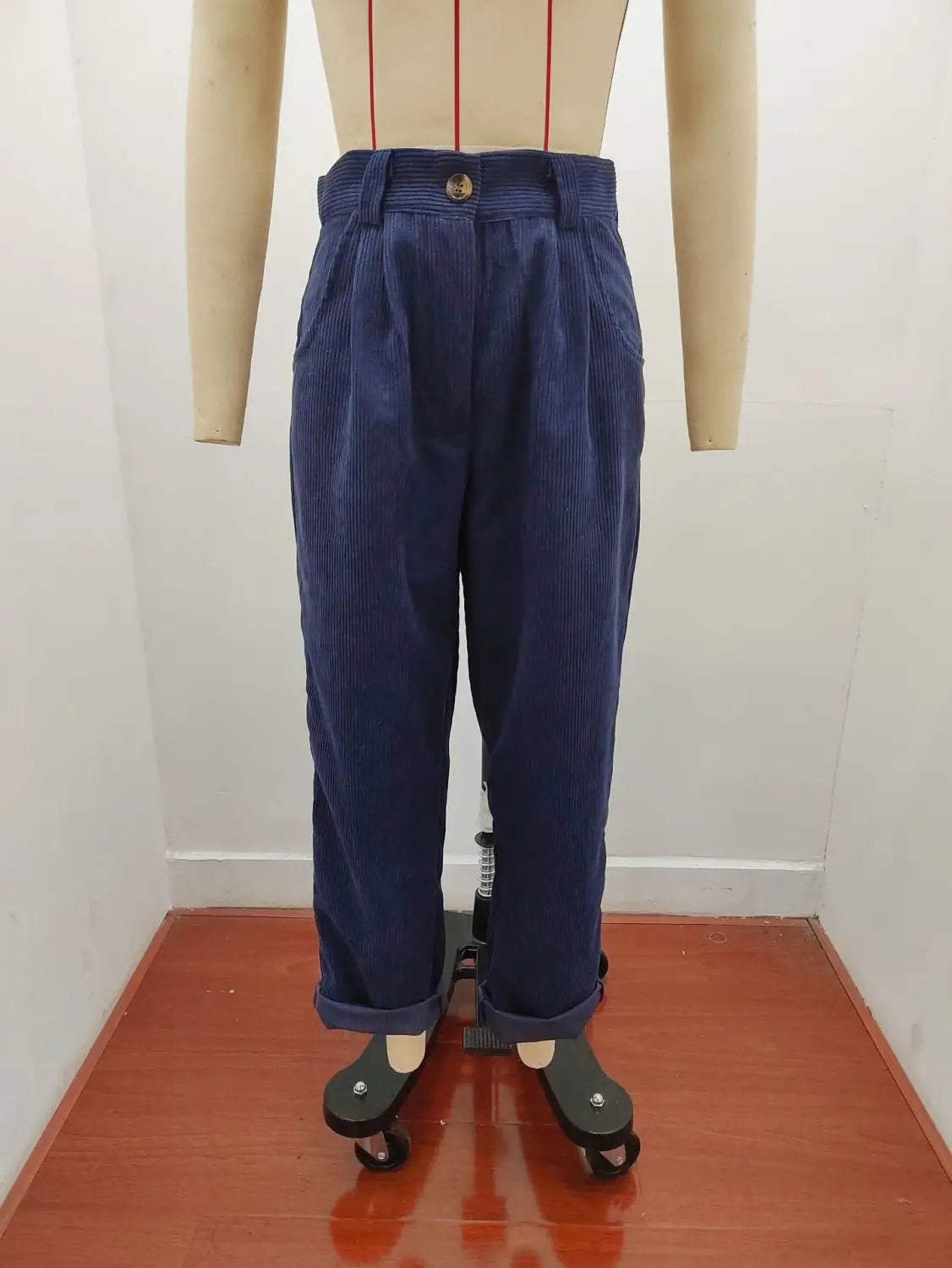 Pantalon en velours côtelé bleu marine taille haute ample avec bas retroussés, présenté de face.