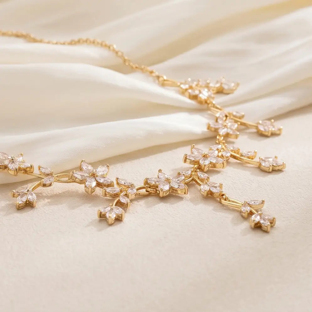 Elegantes goldfarbenes Kristall-Brautkettchen mit zarten floralen Designs, verziert mit funkelnden, klaren Kristallen.