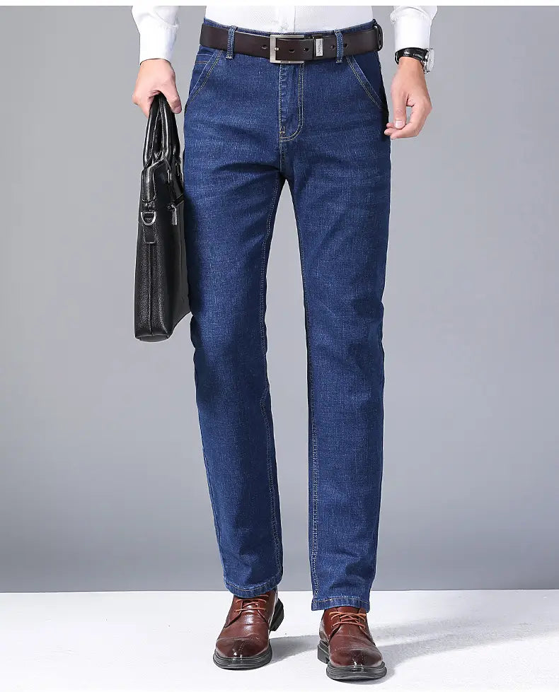 Jeans en denim extensible à coupe slim pour hommes en bleu foncé, avec une coupe classique droite et des détails de surpiqûres visibles.