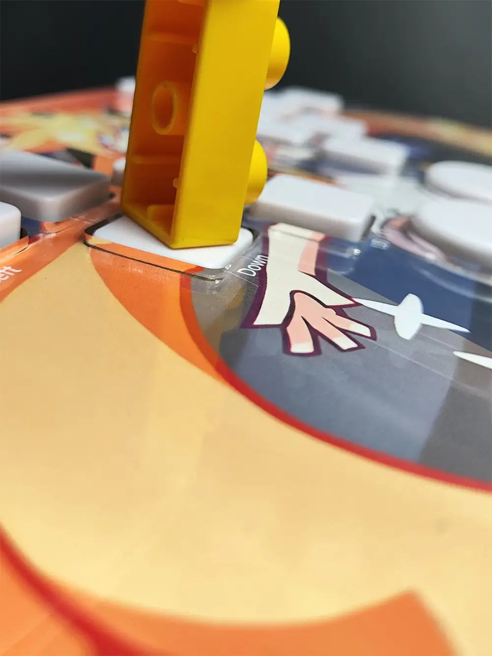 a bright yellow lego brick stands upright on a colorful game board next to the djmax mechanical gaming keyboard featuring left joystick support and joystick moves functionality with data cable connectivity