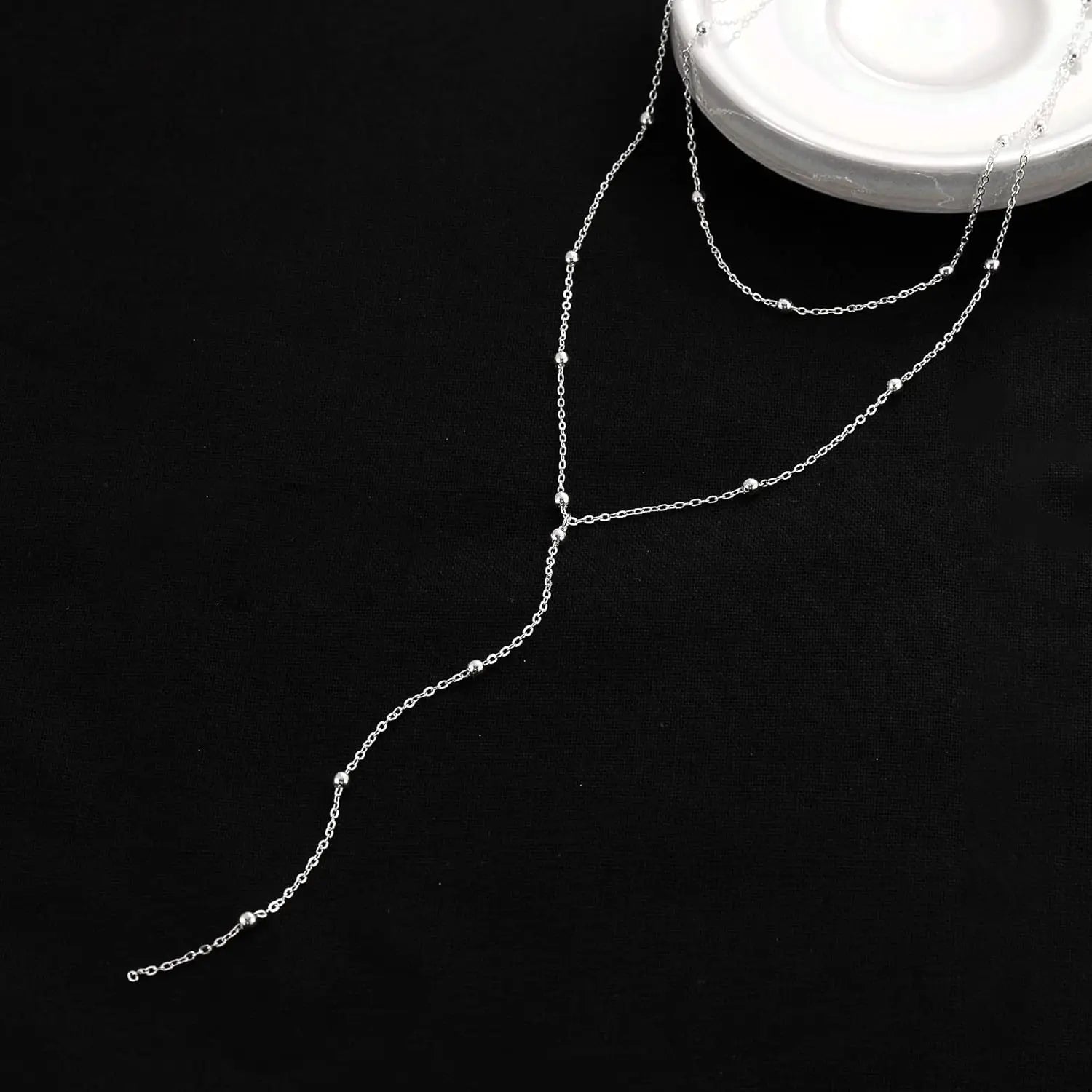 Collier en chaîne argentée avec des détails délicats de perles et un design superposé, pour femmes, dans le style de collier en « y » superposé à l’or.