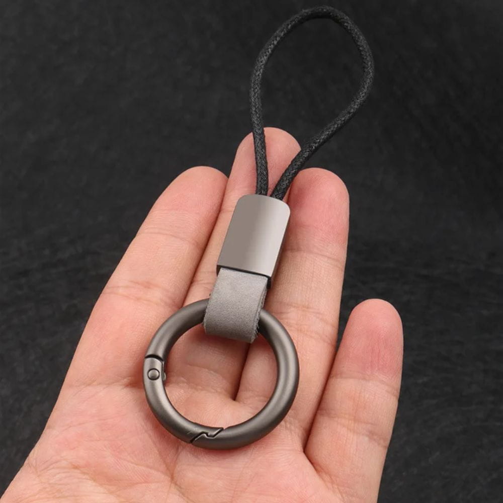A sleek matte gray metal leather braided carabiner keychain with a leather strap and black braided cord.