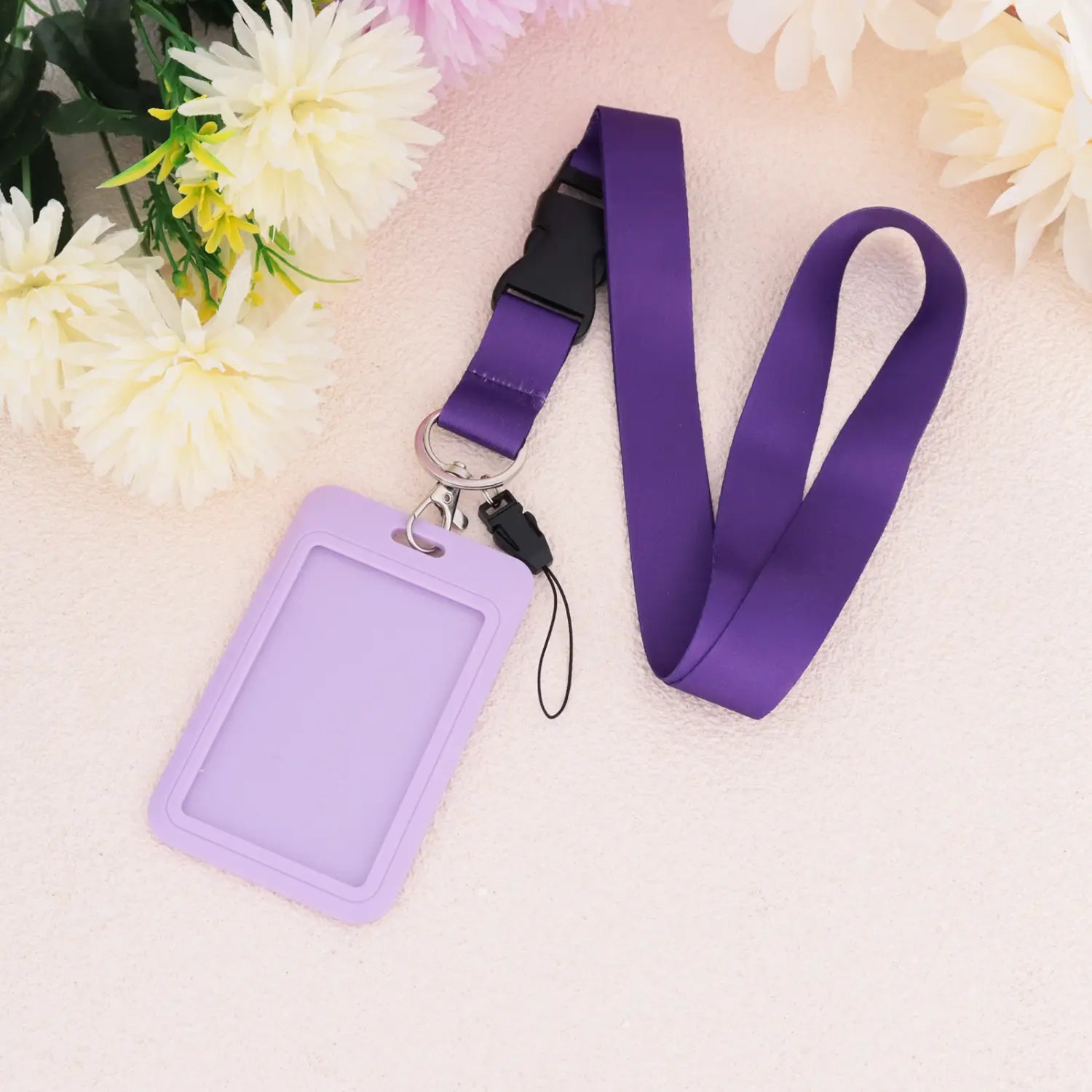 Einfarbiges Lanyard mit einem violetten Silikon-Ausweishalter mit passendem Satinband und einer Schnalle in Metalloptik aus schwarzer Zinklegierung.