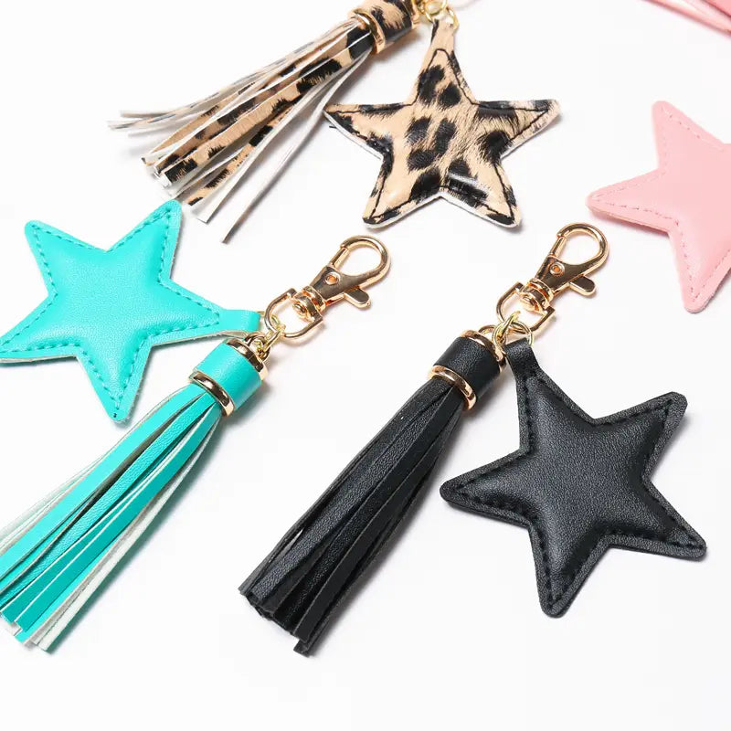 Black star-shaped leather keychain with matching black tassel and gold tone hardware designed for women