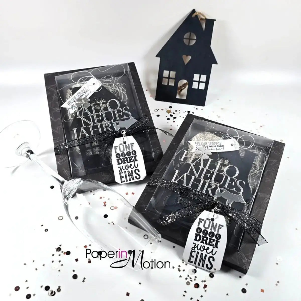 Black paper house decoration with heart and window cutouts made with winter animal metal cutting dies for scrapbooking.