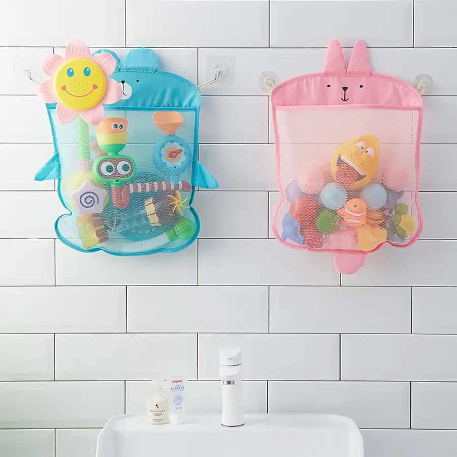 Paires de sacs de rangement pour jouets de bain en filet à thème de dessin animé, bleu et rose, avec de mignons visages d’animaux, suspendus sur un mur carrelé, pour organiser les jouets de bain.