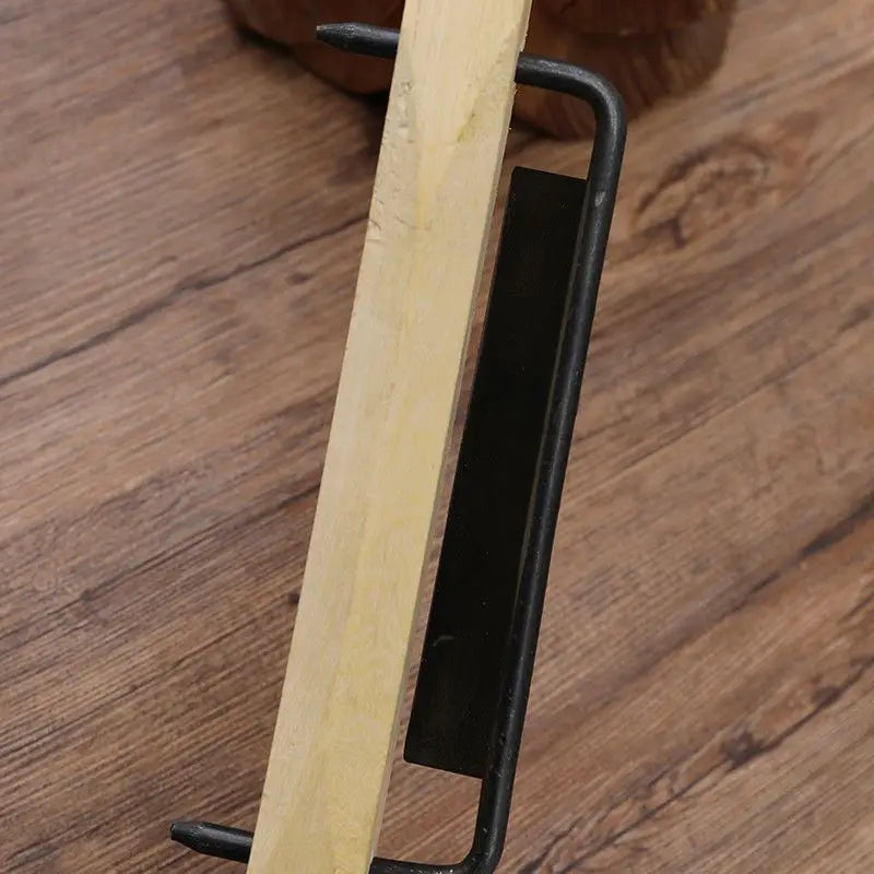 Un serre-livre minimaliste en métal noir, au design épuré et courbé, maintenant une planche en bois de couleur claire aux côtés d’un outil de finition en menuiserie à raboter à la main en bois de rose.