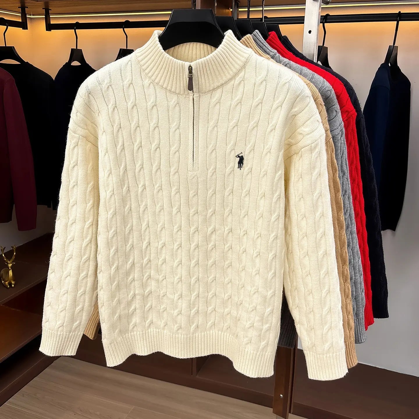 Herren-Designer-Sweater aus cremefarbenem Zopfmusterstrick mit halbem Reißverschluss, mit kleinem besticktem Polo-Spieler-Logo auf der Brust.