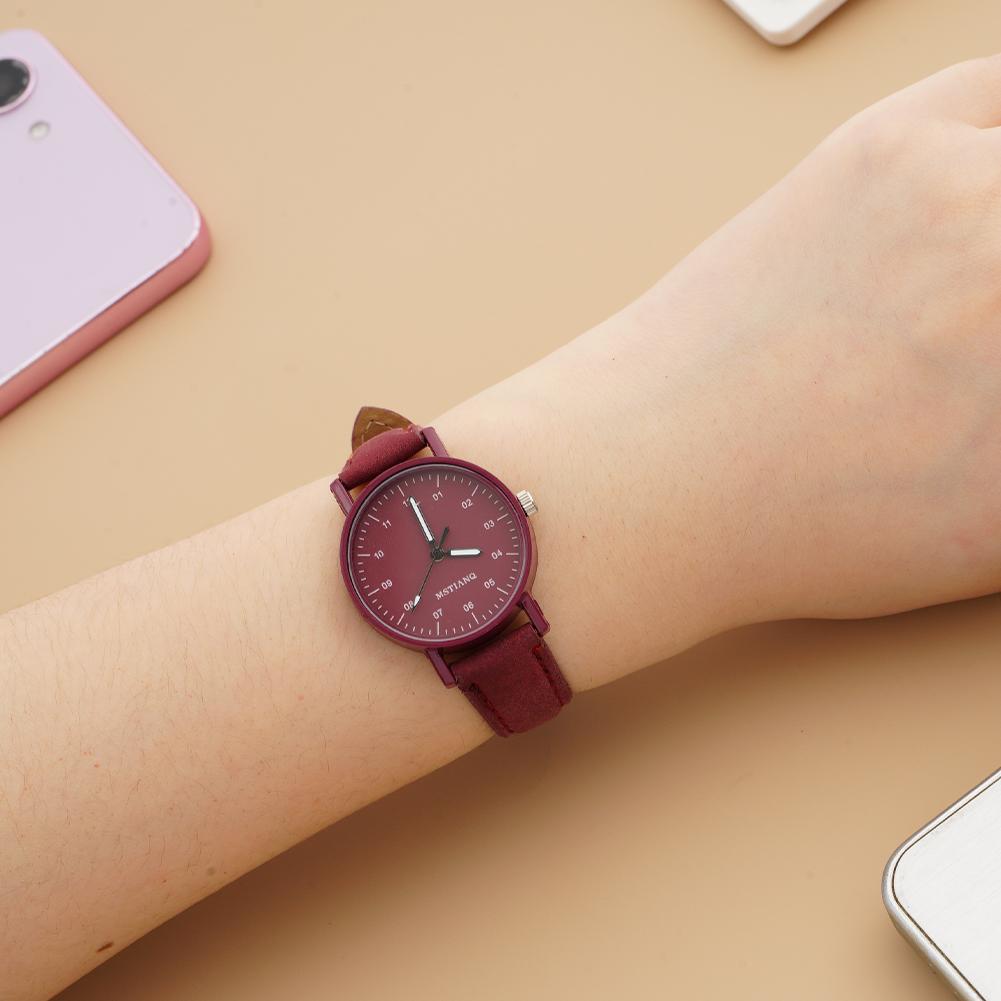 A women quartz watch featuring a maroon pu leather strap, a matching circular face, minimalist silver hands, and a waterproof design.