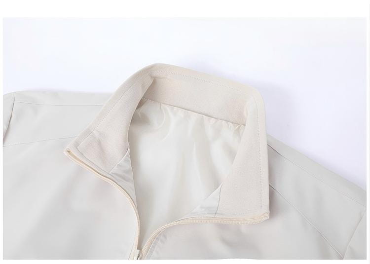 Chaqueta cortavientos ligera para hombre en color beige con cuello vuelto, confeccionada con un tejido liso y resistente al agua, con detalles de costura sutiles.
