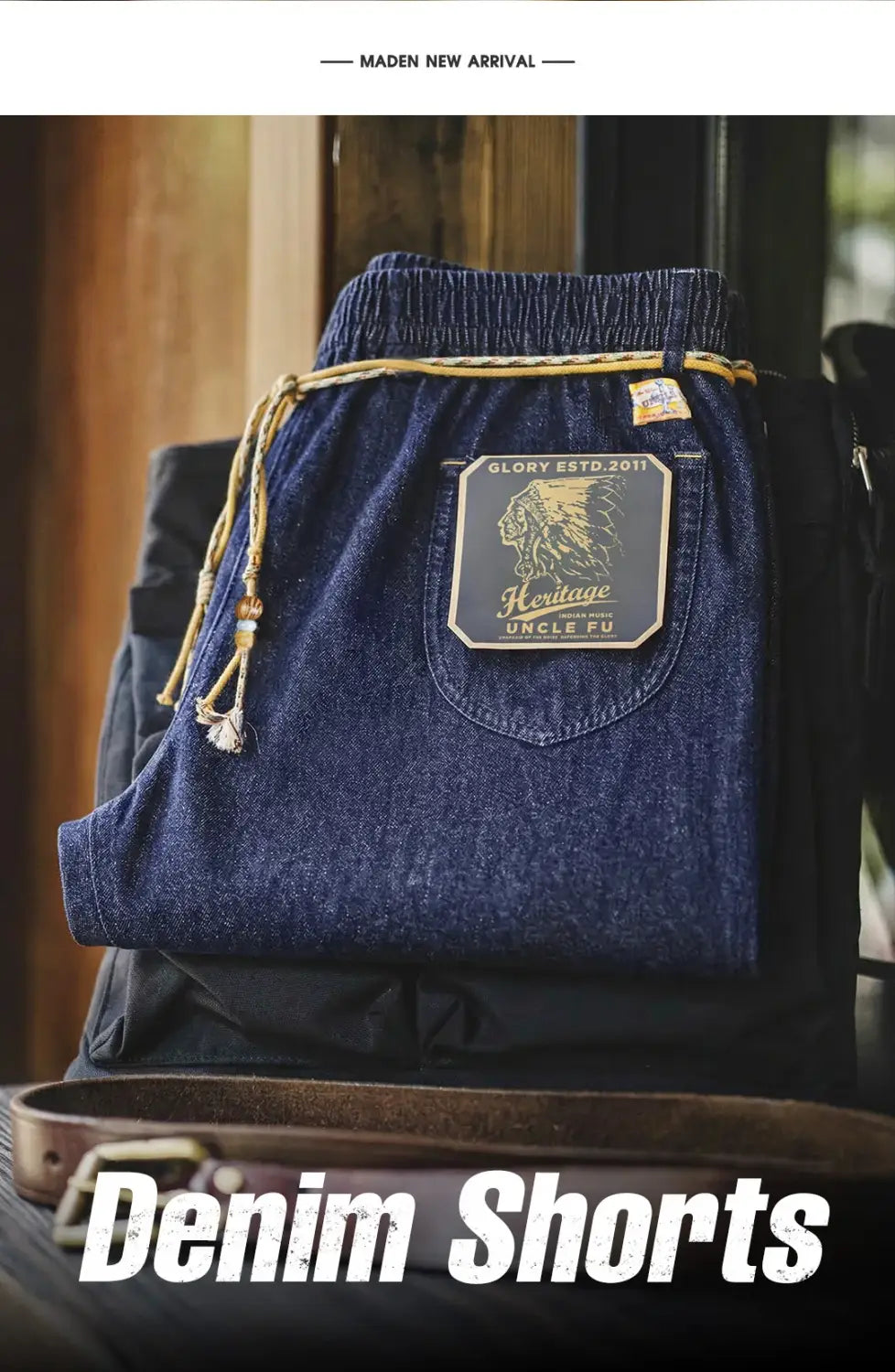 Dunkelblaue Jeansshorts für Herren mit einem Vintage-Style Adler-Patch und Text „heritage uncle fu“ auf der Gesäßtasche sowie hellbraunen Kordelzug-Akzenten, von der Rückseite aus betrachtet.
