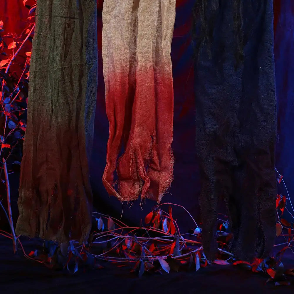 Three hanging textured fabric scarves with distressed edges and ombre dyeing in earthy tones for halloween decorations hanging creepy scarecrow prop.