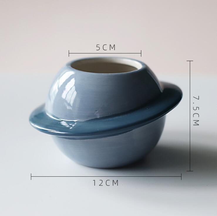 Ein glänzender hellblauer Keramik-Pflanzer in Planetenform mit einem dunkleren blauen Ring, ideal für die Desktop-Dekoration von Sukkulenten