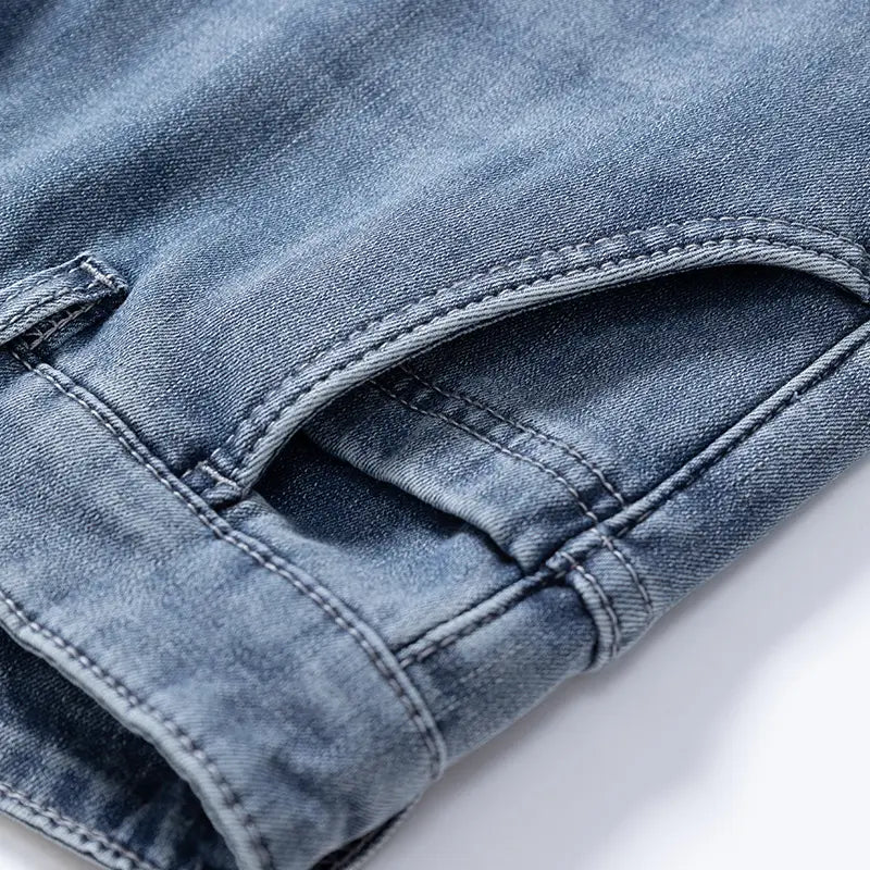Jeans rétro délavés coupe droite ample pour hommes en denim clair, avec une teinte bleu délavé et des détails de surpiqûres visibles.