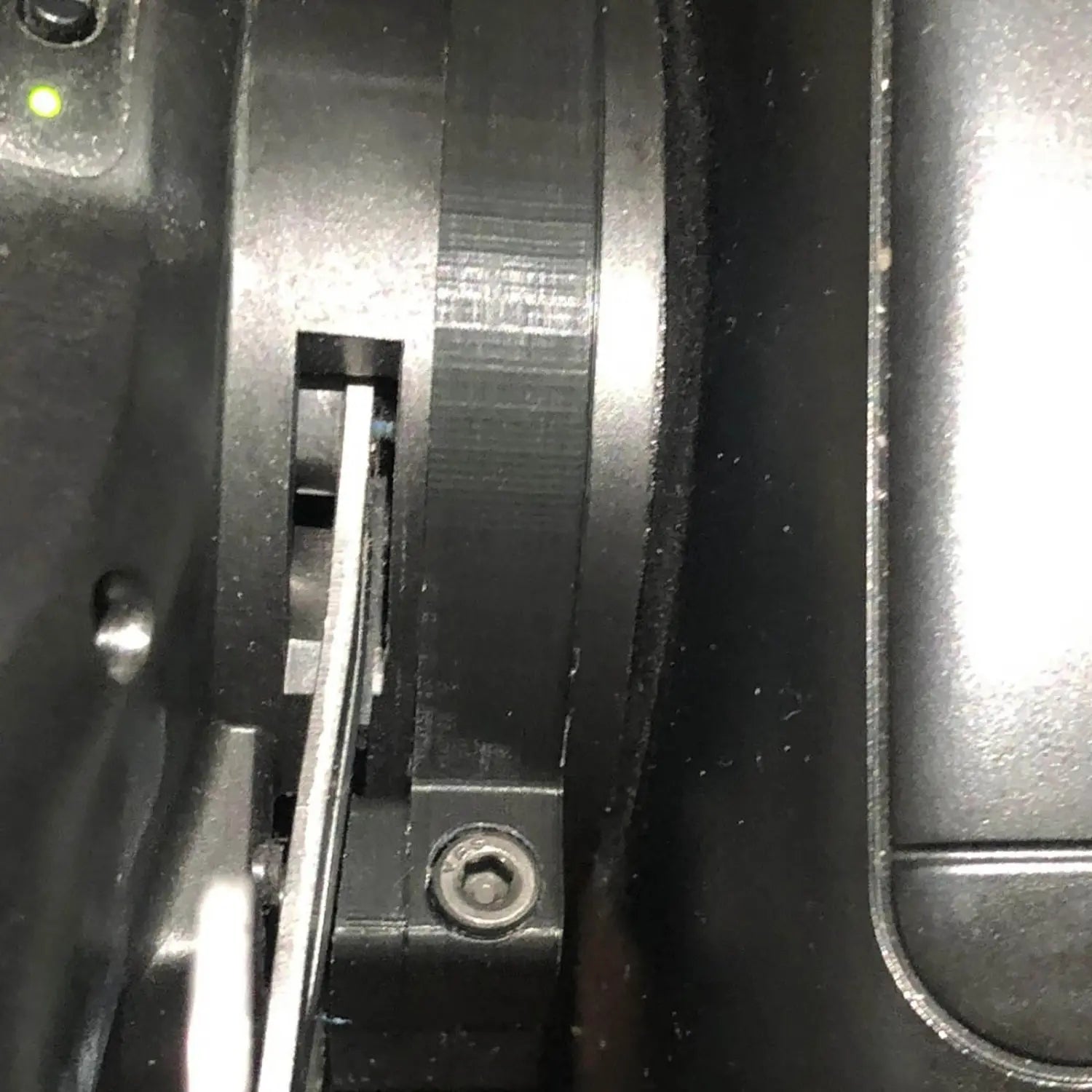 Engranaje de plástico negro con un componente deslizante plateado metálico en el interior de un módulo de varillaje basculante magnético Logitech compatible con volantes de carreras G29 G920 y G923.