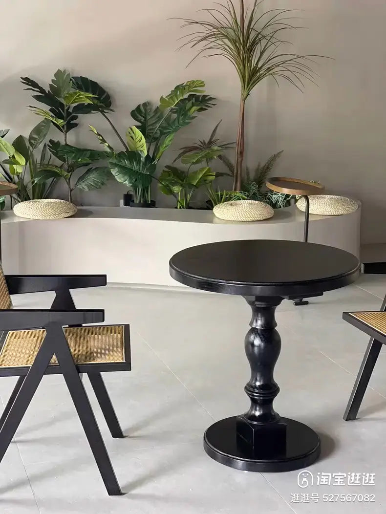 Black wooden pedestal round accent table with glossy finish and ornate turned legs.