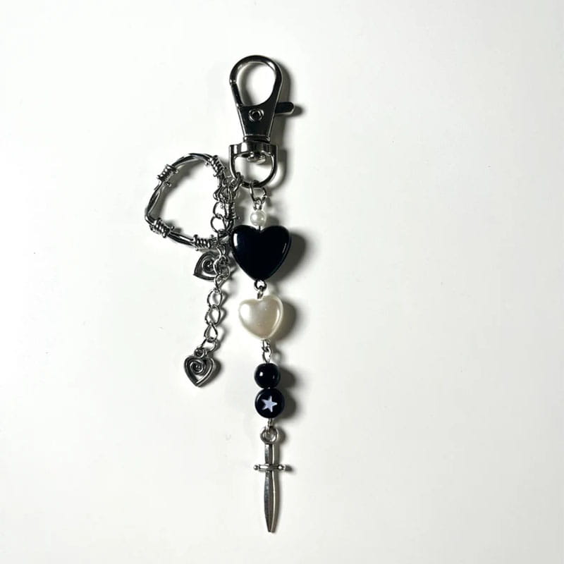 Porte-clés à thème cœur noir et argenté, avec une chaînette, des perles à l’apparence de perles et un pendentif en forme de dague, destiné à un usage comme accessoire esthétique.