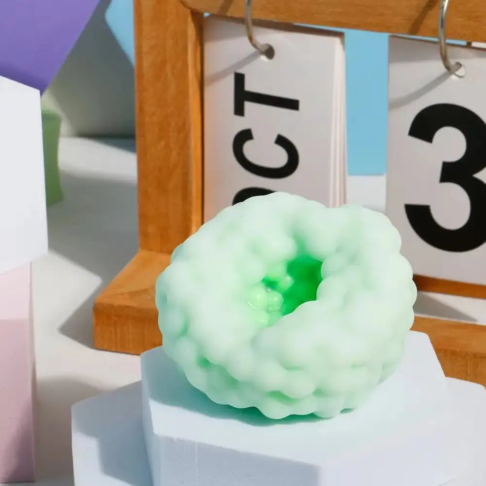 un jouet anti-stress souple en peau de neige en forme de nuage, vert menthe, avec une finition brillante et un centre vert subtil visible de face