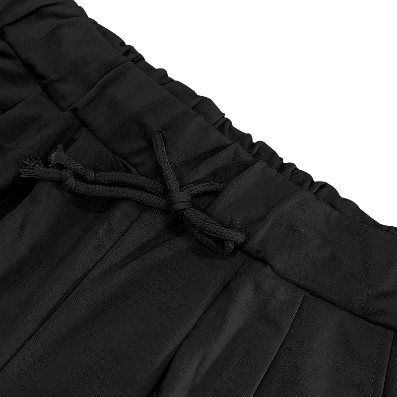 Pantalones negros con cordón, con tejido suave ligeramente texturizado y cordón atado con orden en la cintura, del conjunto veraniego casual para hombre de dos piezas, camiseta y pantalones cortos.