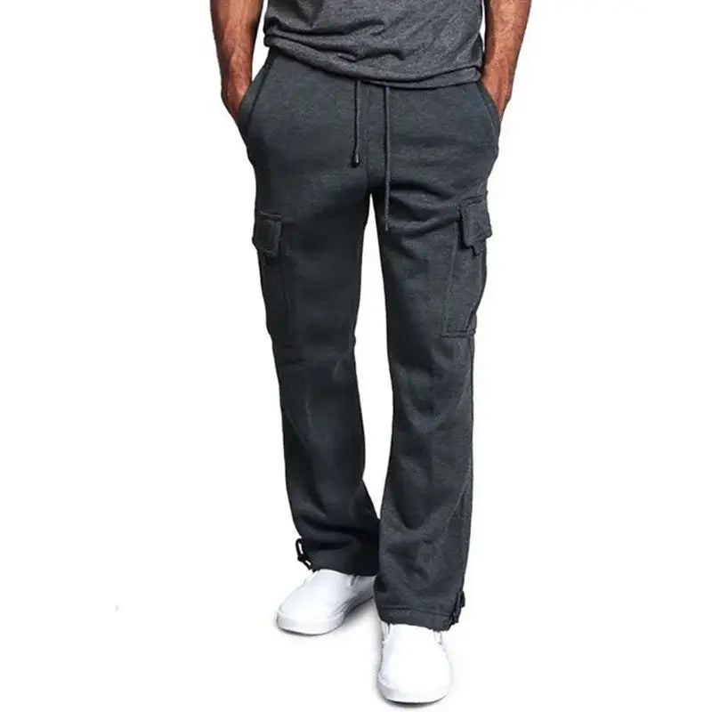 Pantalon cargo homme en molleton gris foncé, doté de plusieurs poches et d’une taille à cordon de serrage.