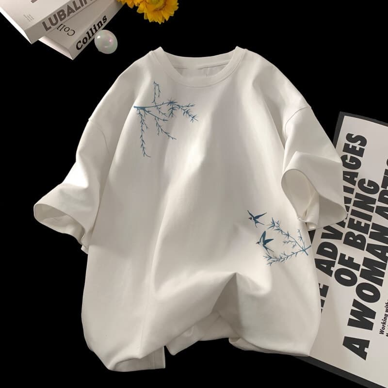 Camiseta de algodón oversize blanca con delicadas ramas bordadas en azul y pájaros en la parte delantera, de la colección de pájaros bordados.