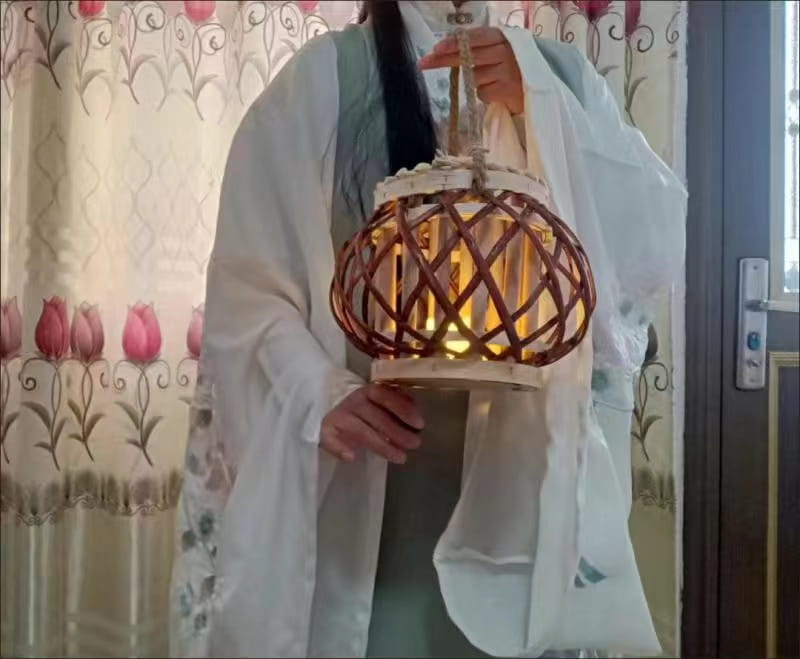 Un porte-bougie en bambou tissé, lumineux et chaleureux, avec une armature en osier et une bordure décorative blanche, idéal pour la décoration intérieure du domicile et pour recevoir des avis positifs.