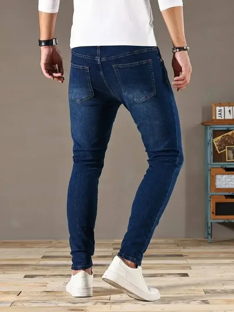 Jeans en denim bleu foncé coupe slim pour homme présentés de dos, avec des poches classiques et une coupe ajustée.