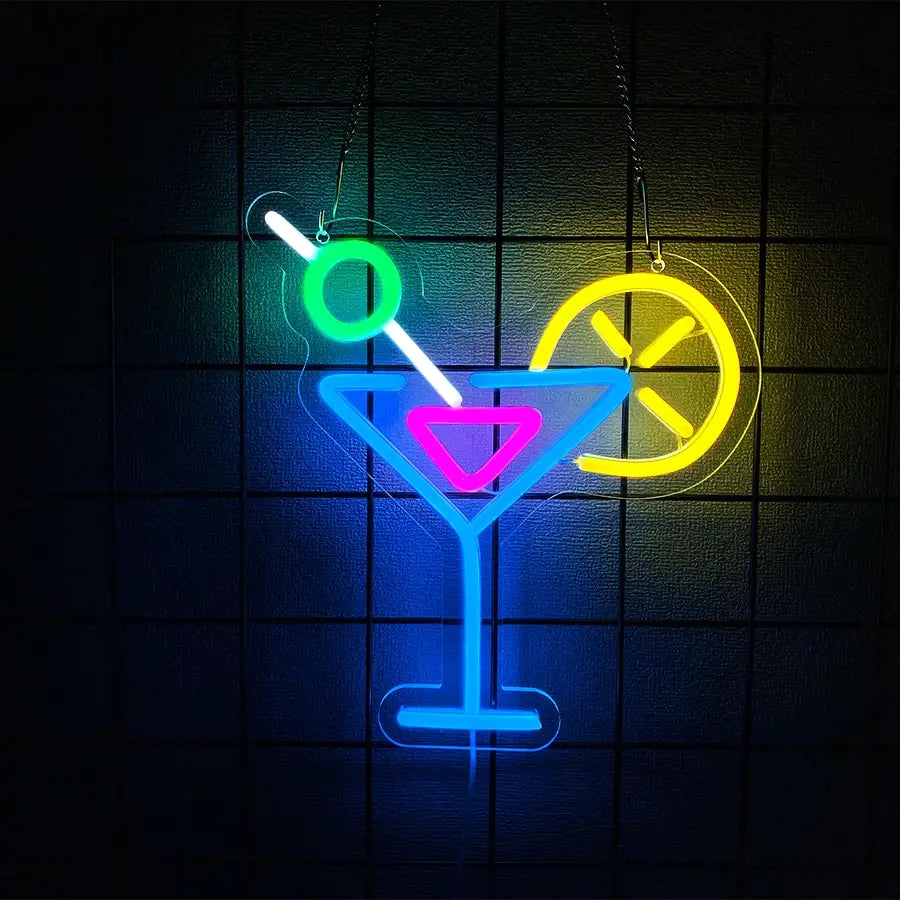 Enseigne néon « Cocktails and dreams » présentant un design de verre à martini vibrant, avec un contour bleu, un centre de liquide rose, une partie centrale verte et un agitateur de cocktail blanc, ainsi qu’un accent de tranche de citron jaune.
